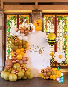 Scénographie backdrop, décoration ballons pour un baptême à Annecy, thème abeille au domaine de la Médicée.